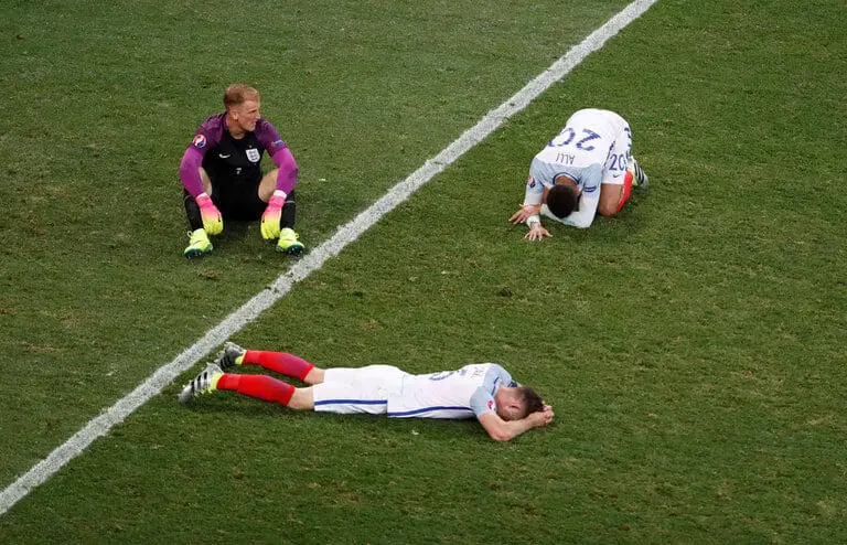 three football players lying on the court grass after losing a game