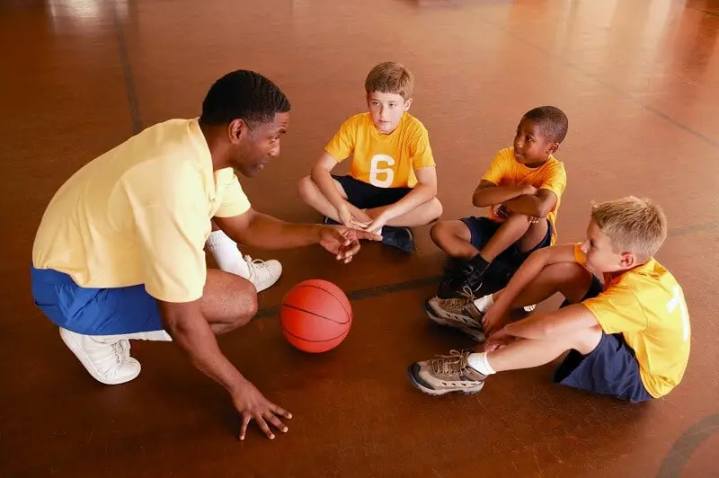 coach with basketball players on the court